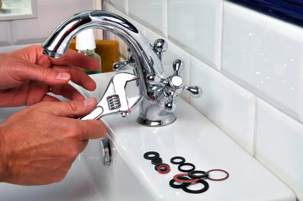 Plumber performing maintenance on a bathroom faucet in Villa Rica