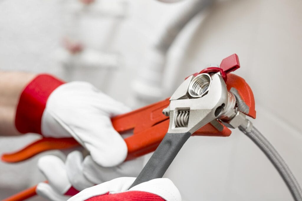 Plumber holding pipe wrenches for an emergency repair in Villa Rica