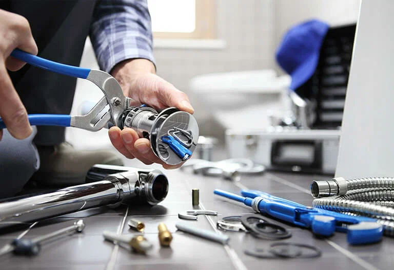 Technician repairing a plumbing fixture with professional tools in Villa Rica