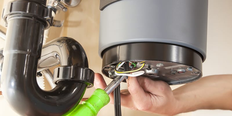 Technician repairing the heating element of a water heater in Villa Rica