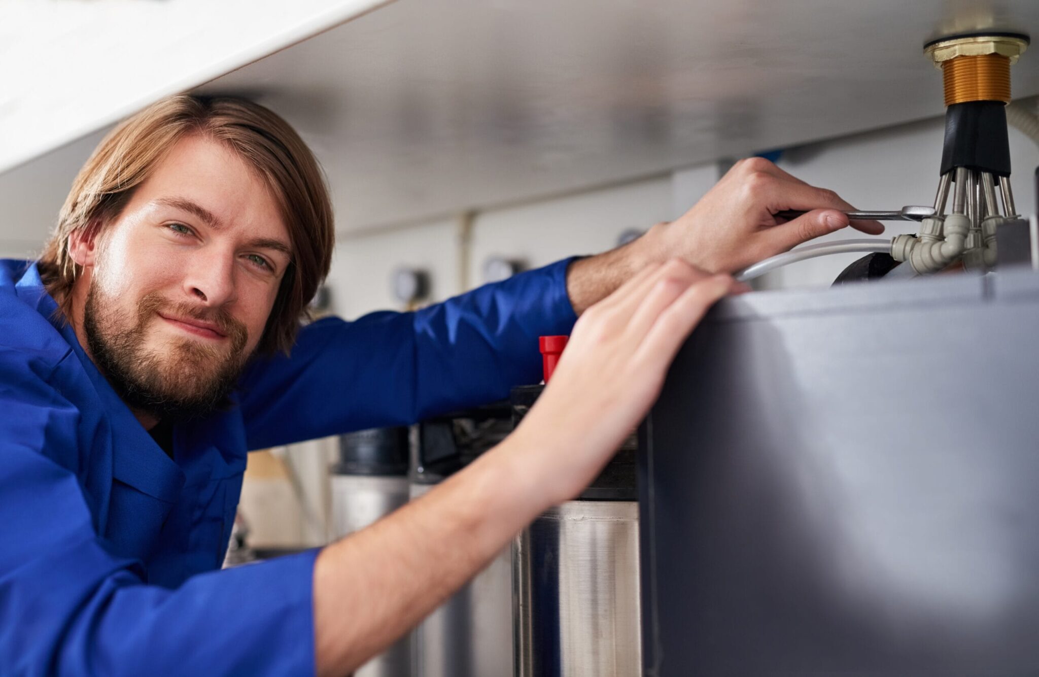 Technician servicing a residential water heater tank in Villa Rica