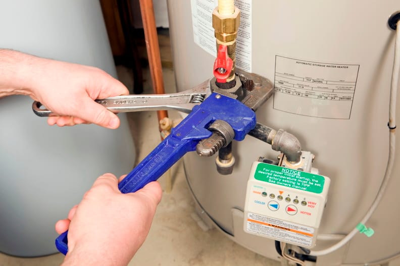 Plumber repairing a water heater valve in Villa Rica